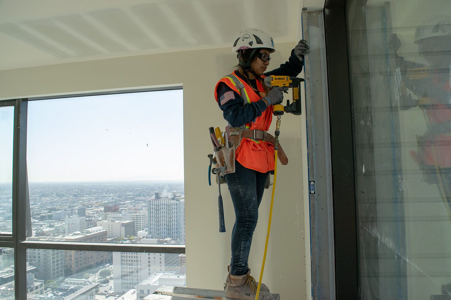 women construction hanging drywall