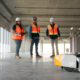 3 Swinerton employees holding remote that is driving the robot named Dusty